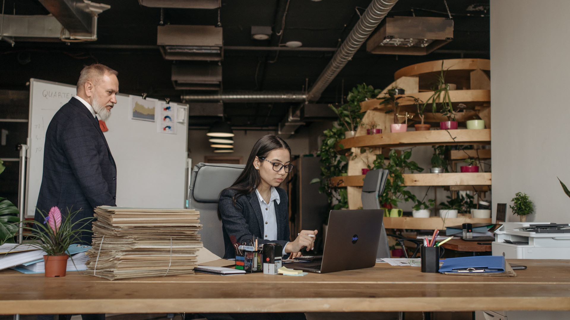 Responsable RH travaillant sur ordinateur portable avec des documents de contrat dans un bureau moderne